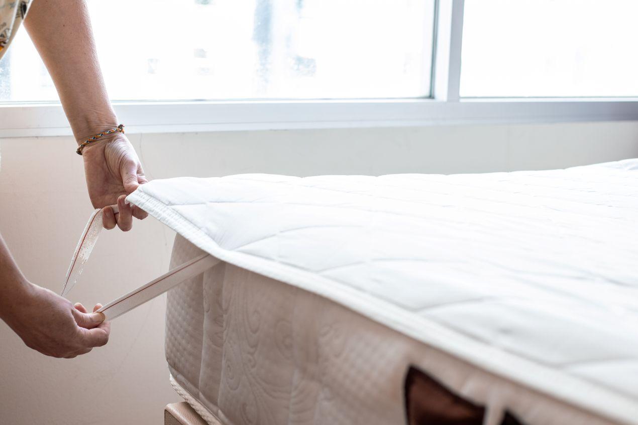 Hand-befestigt-Matratzenschutz-an-Matratze-fuer-bessere-Betthygiene-und-Allergieschutz