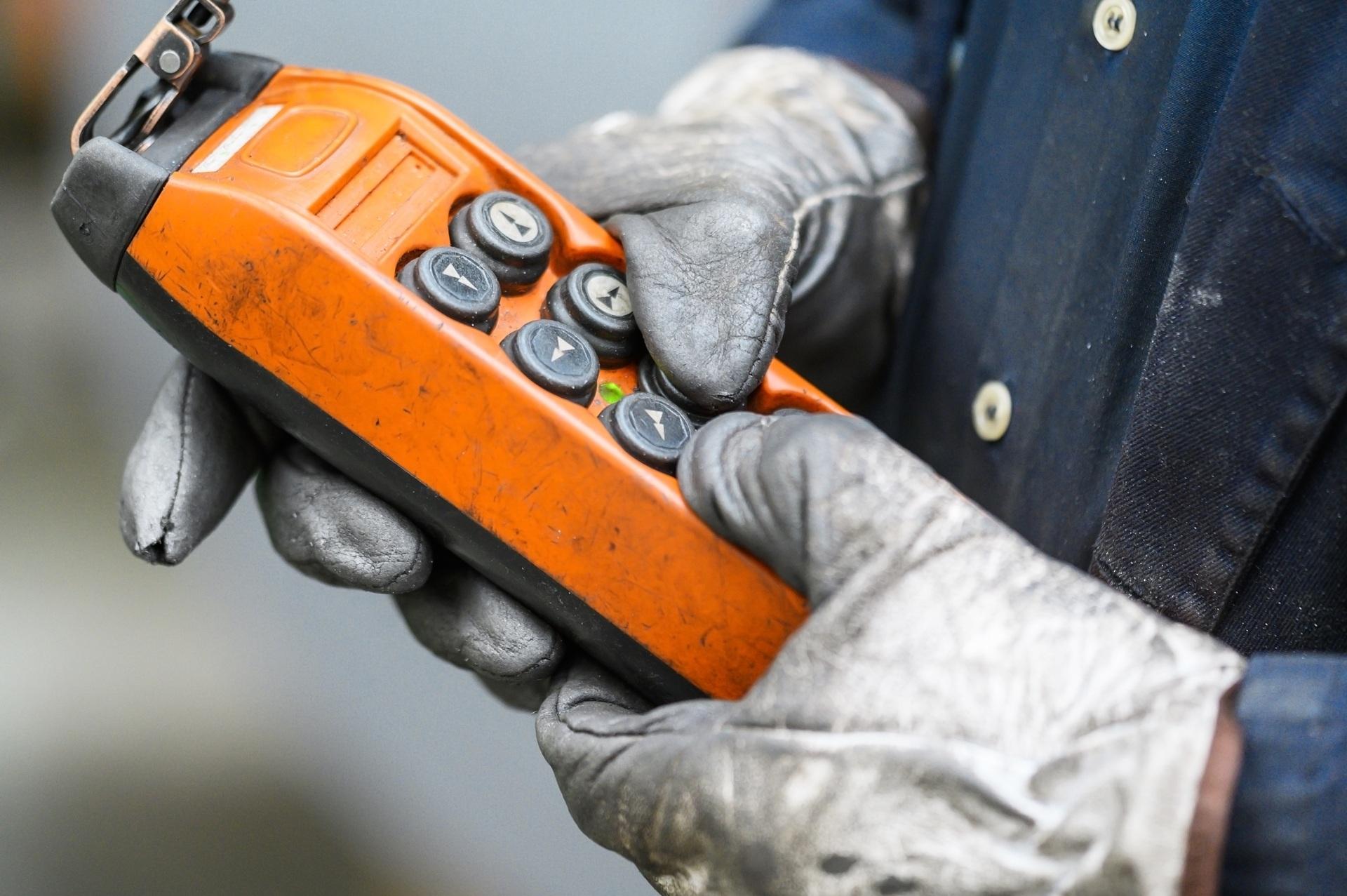 Hand mit Steuerpult in Montagehalle | Elektrokettenzuege